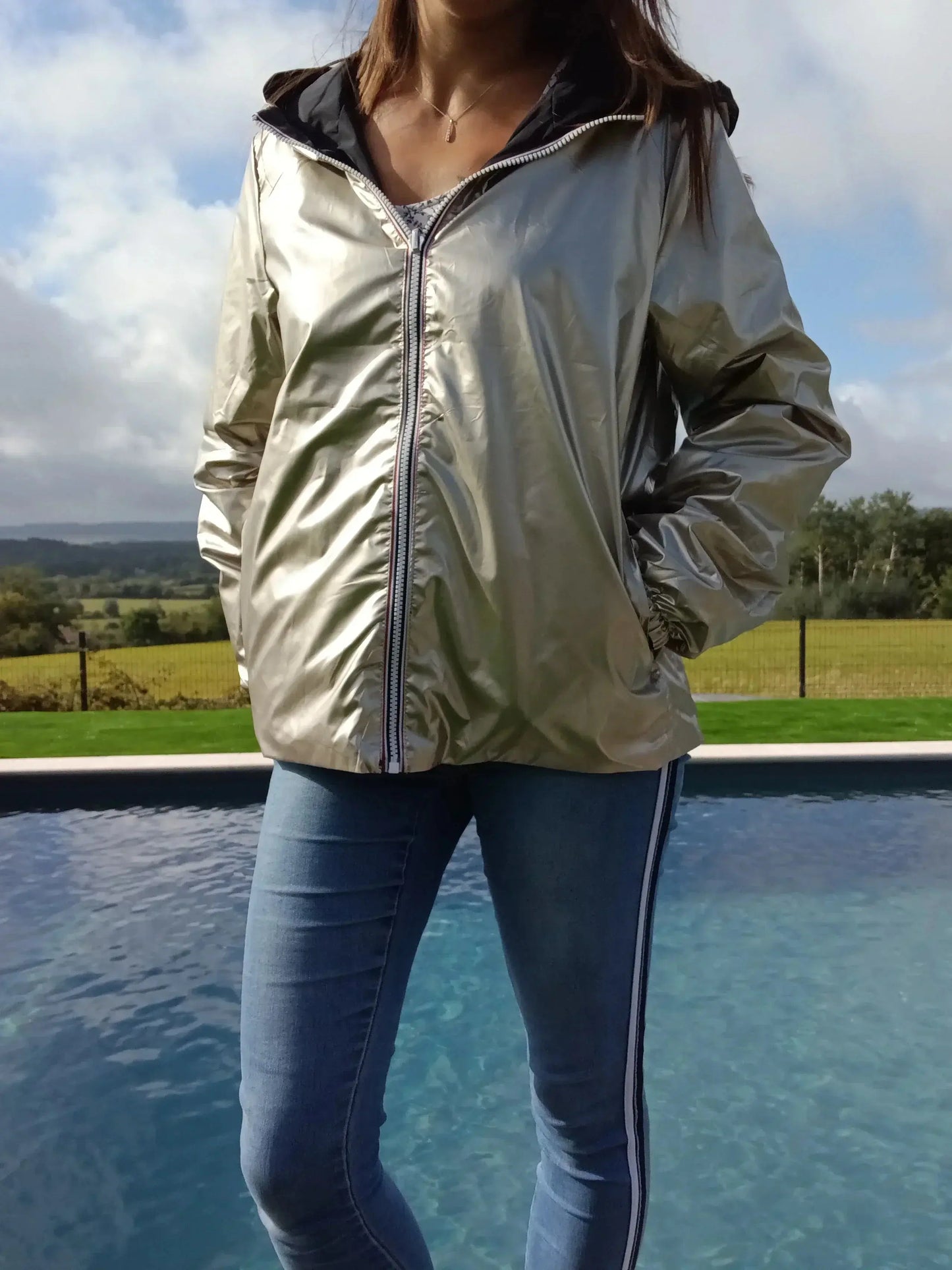 Manteau court réversible imperméable noir et doré de Melya Melody, affichant une coupe élégante et un design moderne.