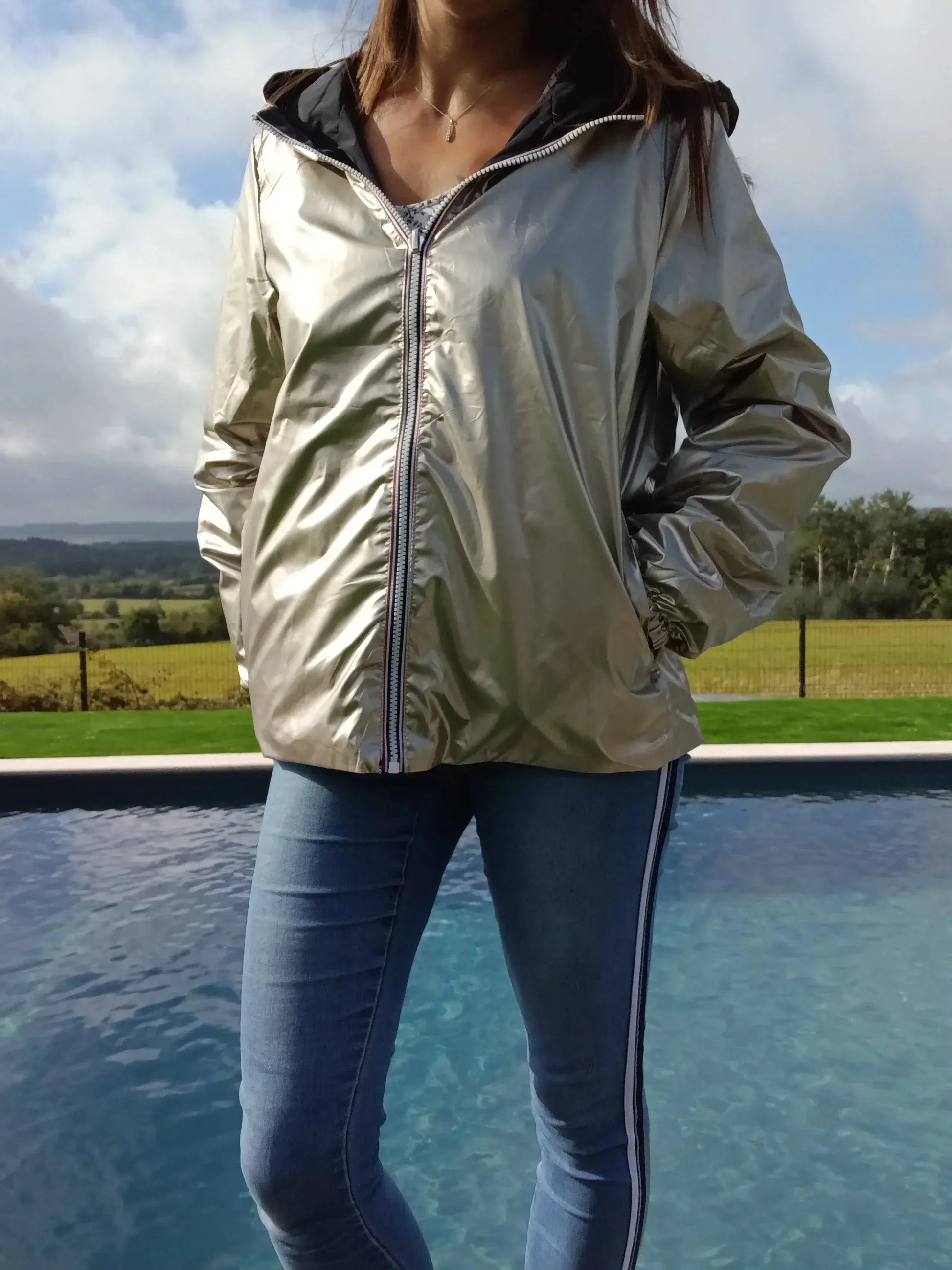 Manteau court réversible imperméable noir et doré de Melya Melody, affichant une coupe élégante et un design moderne.