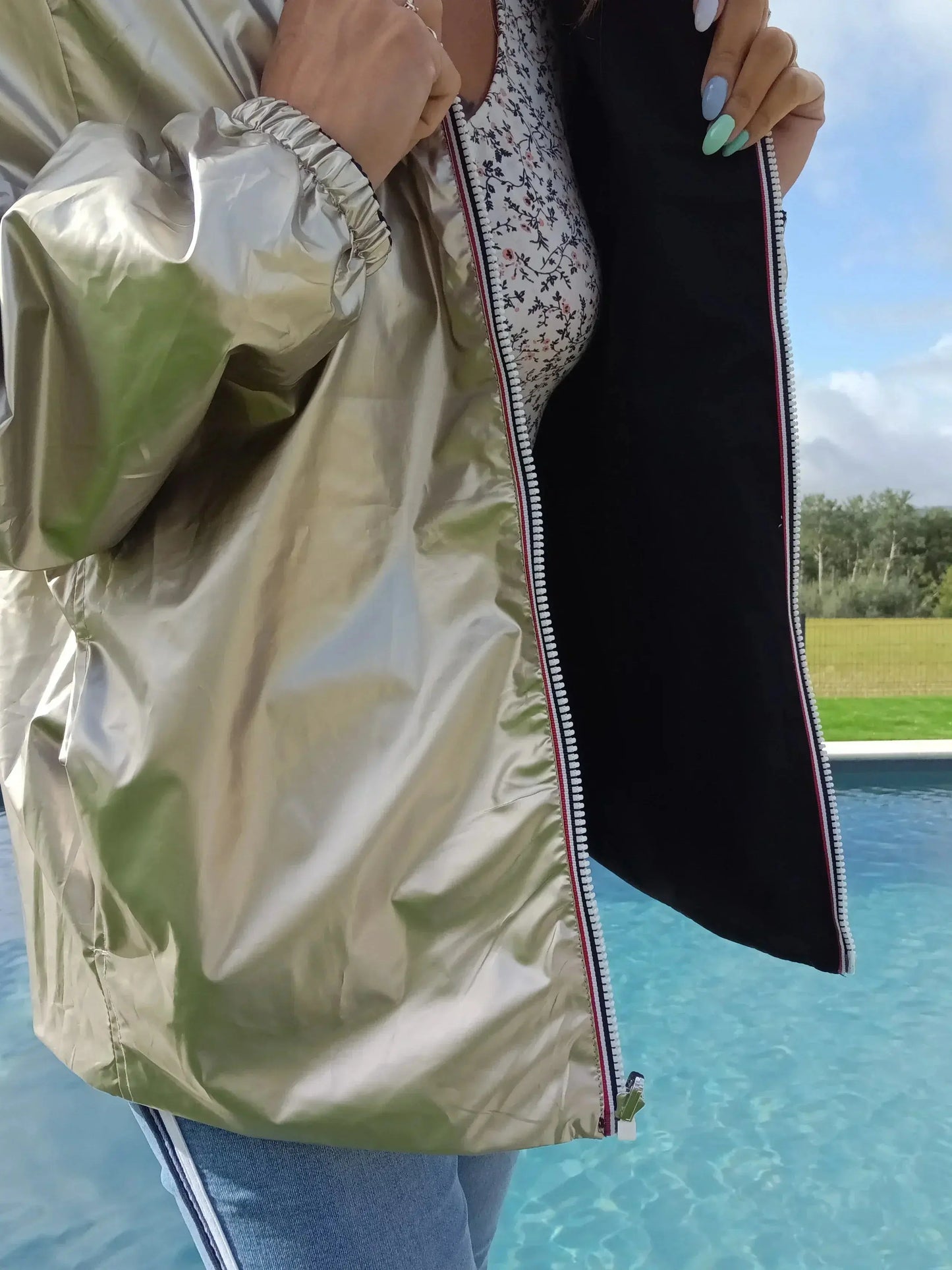 Manteau court réversible imperméable noir et doré de Melya Melody, visible avec ses côtés colorés et finition élégante.