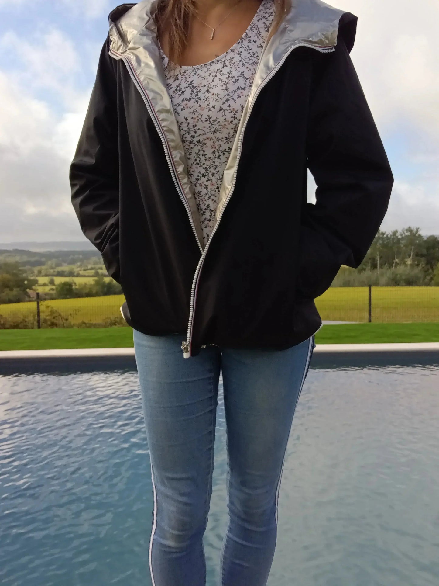 Manteau court réversible imperméable noir et doré de la marque Melya Melody, avec fermeture et poches visibles.