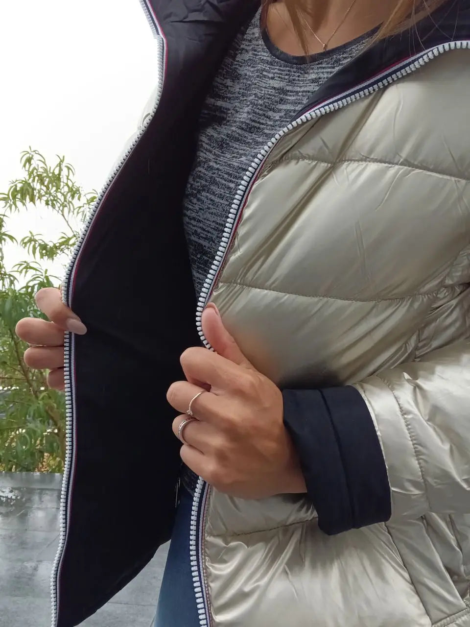 Manteau court réversible Melya Melody, imperméable, matelassé noir et doré, porté sur un mannequin, style élégant et pratique.