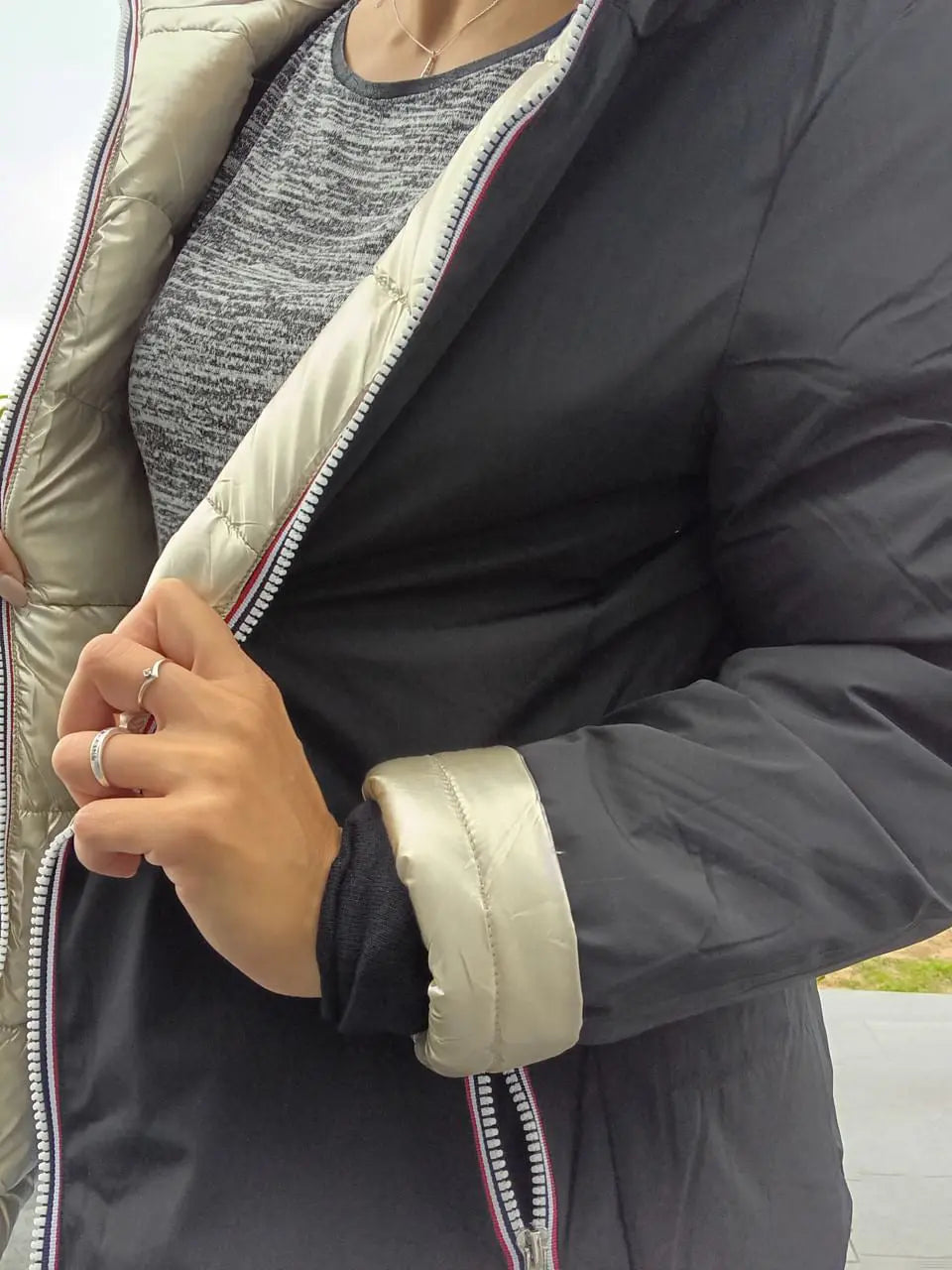 Manteau court réversible Melya Melody, imperméable et matelassé, noir et doré, porté sur un mannequin.