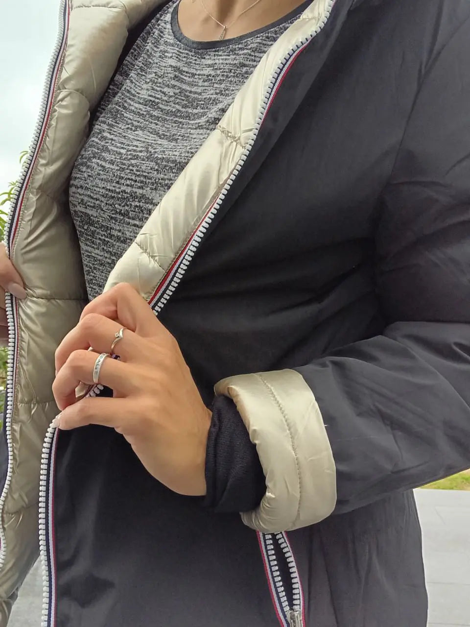 Manteau court réversible et imperméable Melya Melody en matelassé noir et doré, affiché sur un modèle.