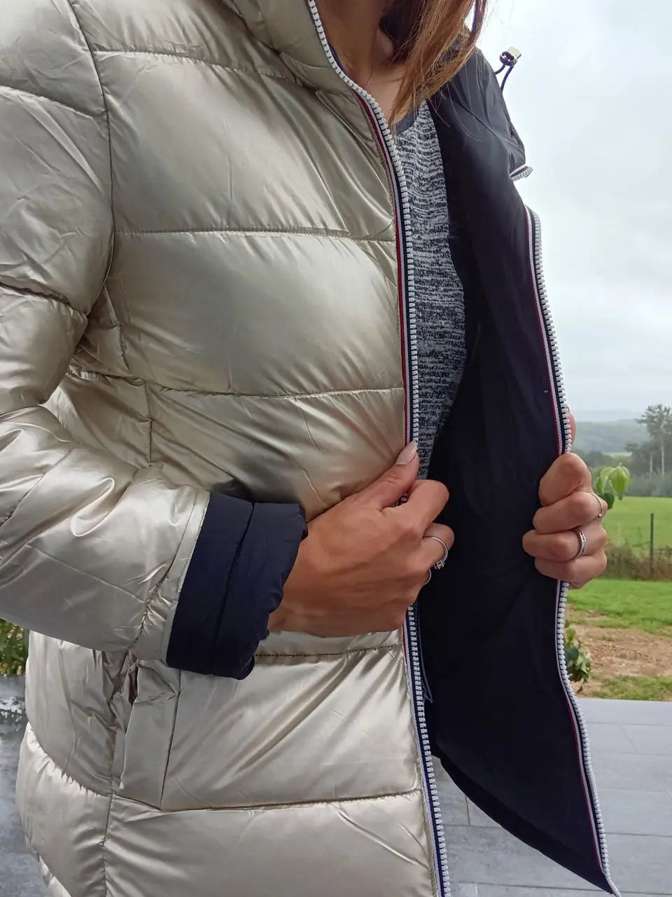 Manteau court réversible Melya Melody, imperméable et matelassé noir et doré, affiché sur un mannequin.