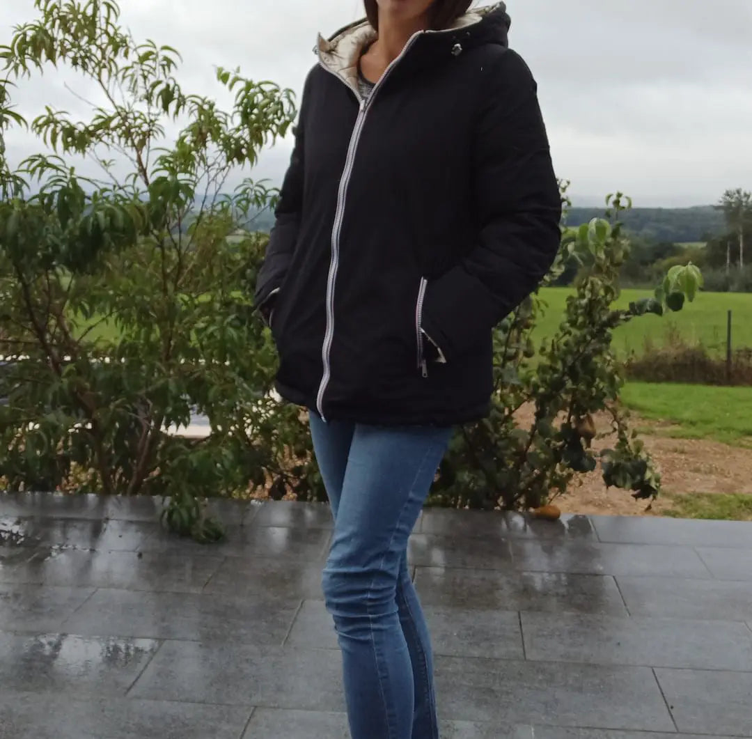 Manteau court réversible Melya Melody, imperméable, matelassé noir et doré, visible avec détails du tissu et du design.