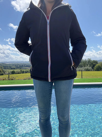 Manteau court réversible Melya Melody imperméable, matelassé noir et doré, avec capuche et fermeture éclair visible.