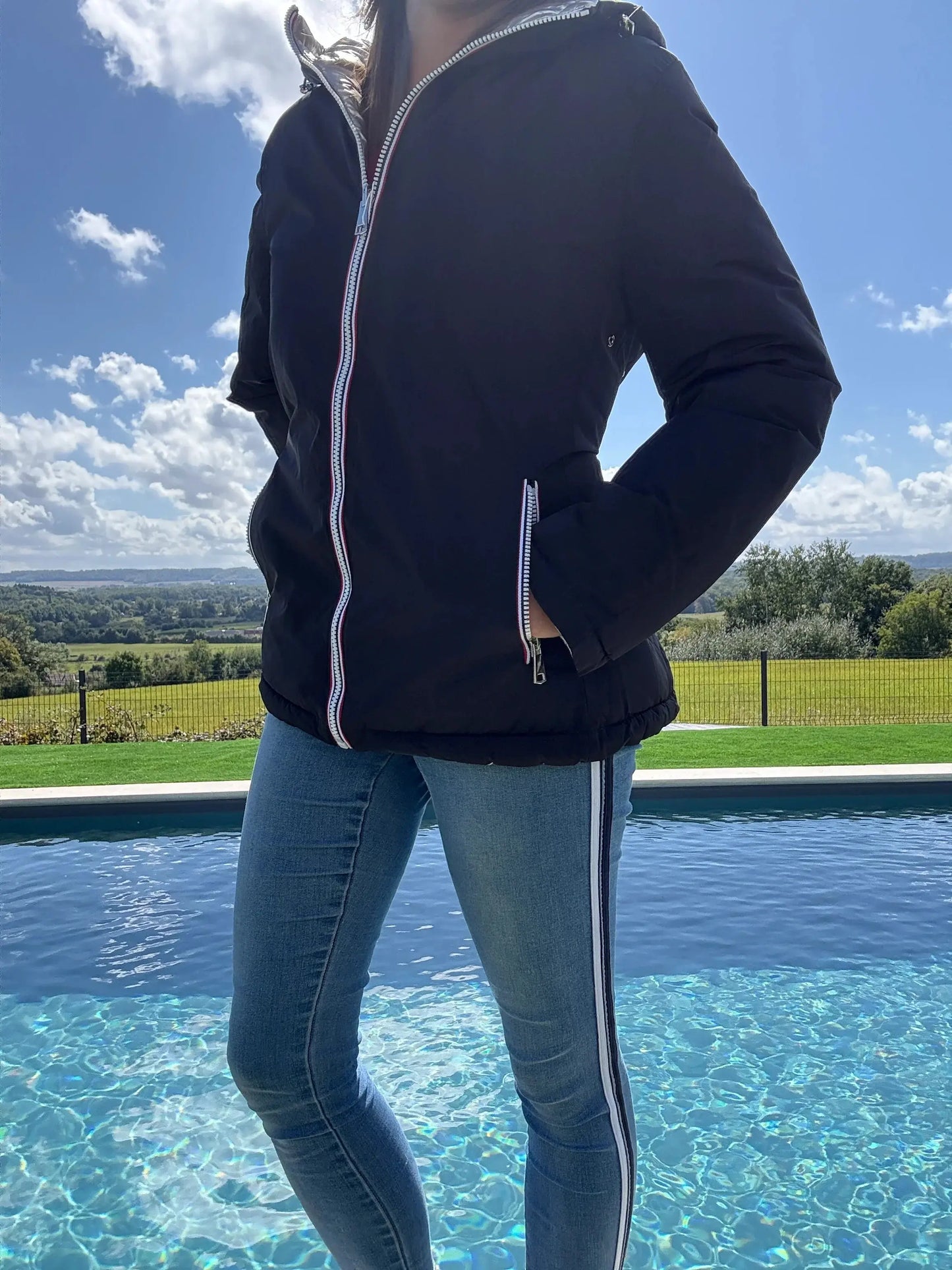 Manteau court réversible imperméable noir et doré Melya Melody avec matelassage, porté en extérieur.