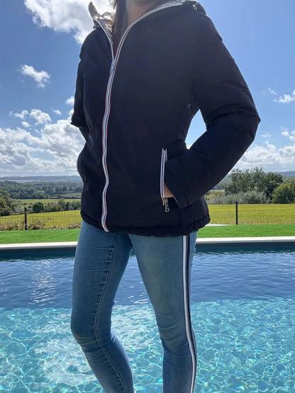 Manteau court réversible imperméable noir et doré Melya Melody avec matelassage, porté en extérieur.