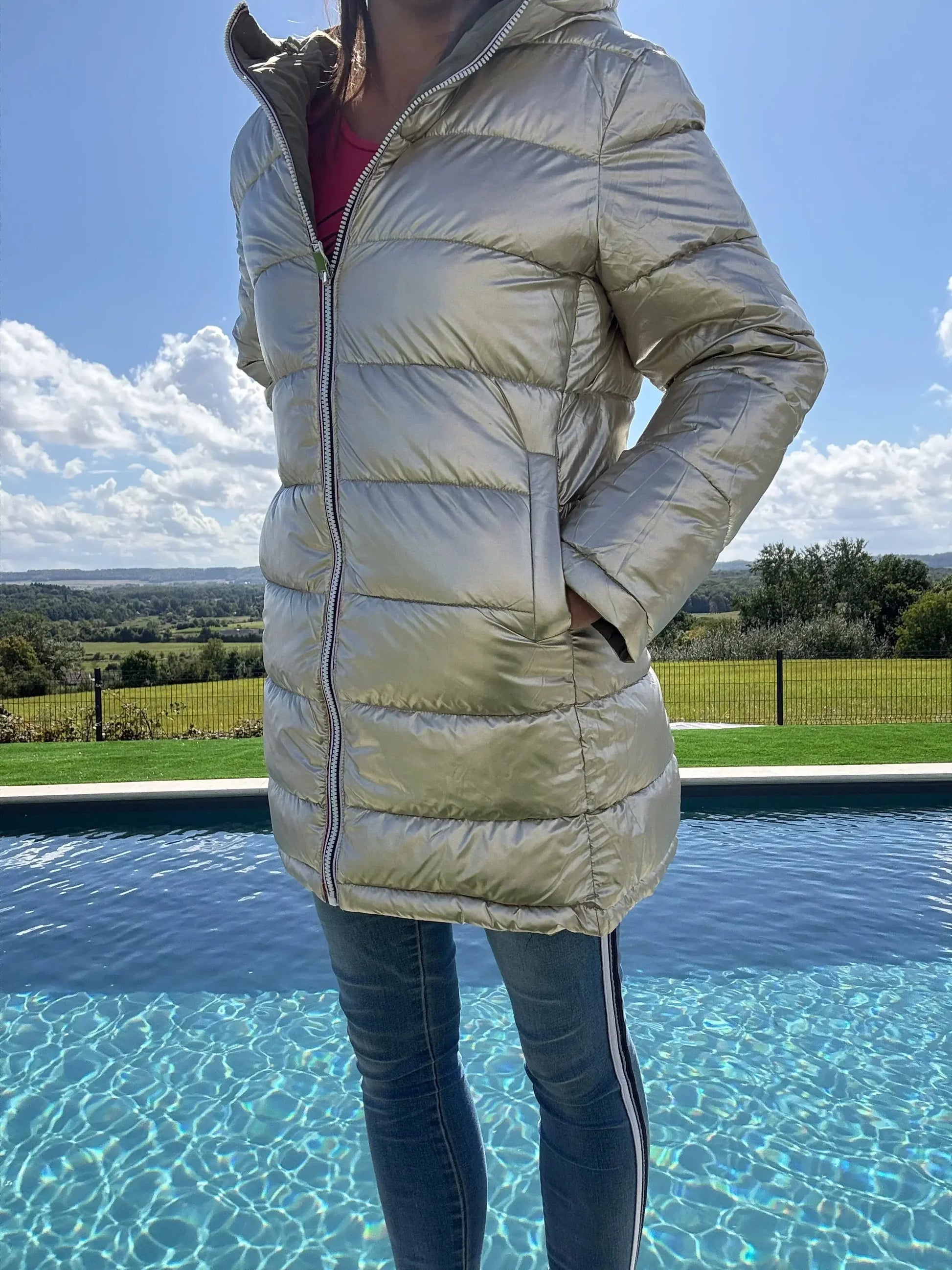 Manteau long réversible et imperméable Melya Melody en kaki clair et doré, matelassé, avec capuche et fermeture zippée.