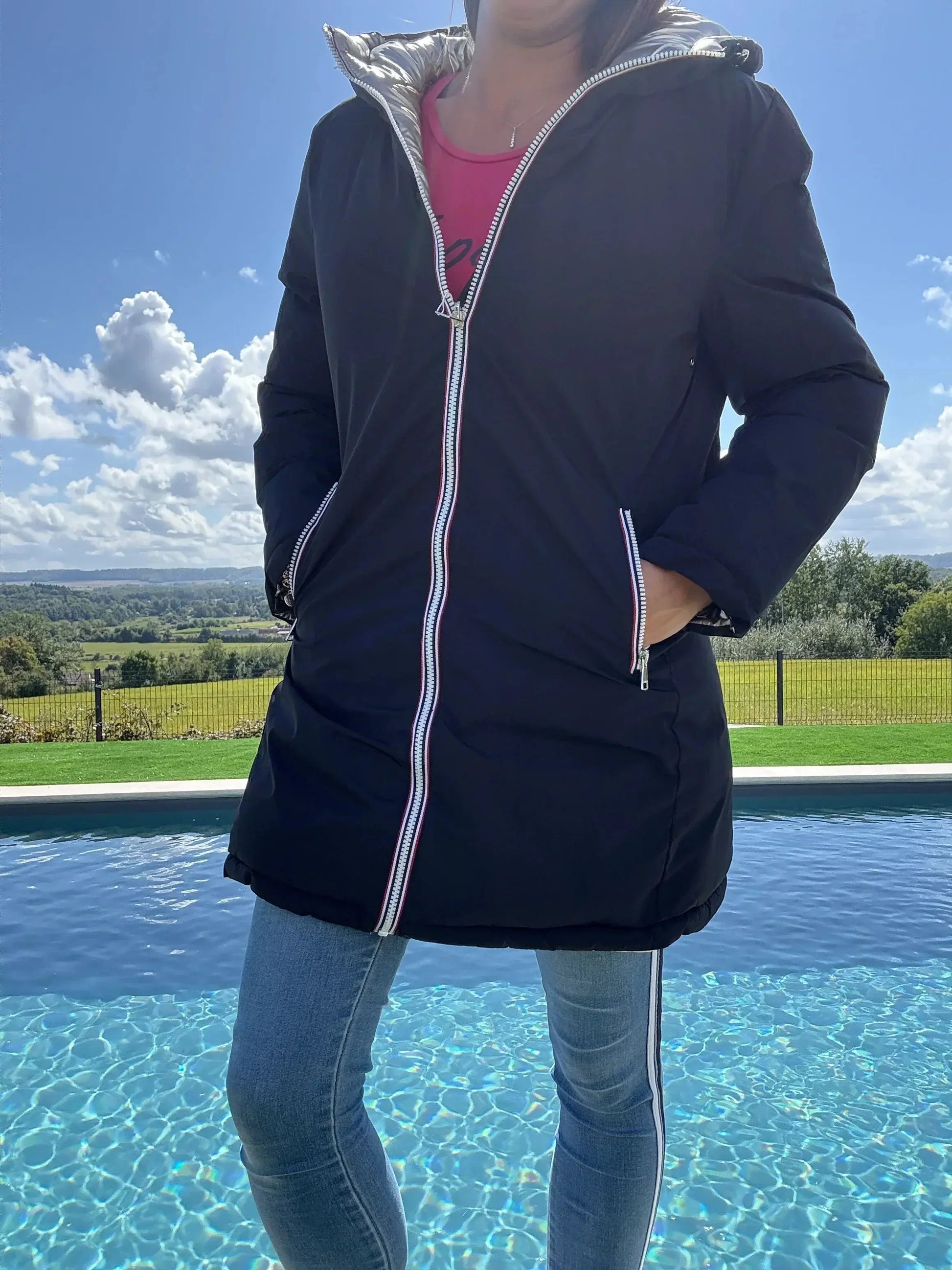 Manteau long réversible Melya Melody en matelassé noir et doré, imperméable, avec couture visible et doublure brillante.