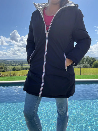 Manteau long réversible Melya Melody en matelassé noir et doré, imperméable, avec couture visible et doublure brillante.
