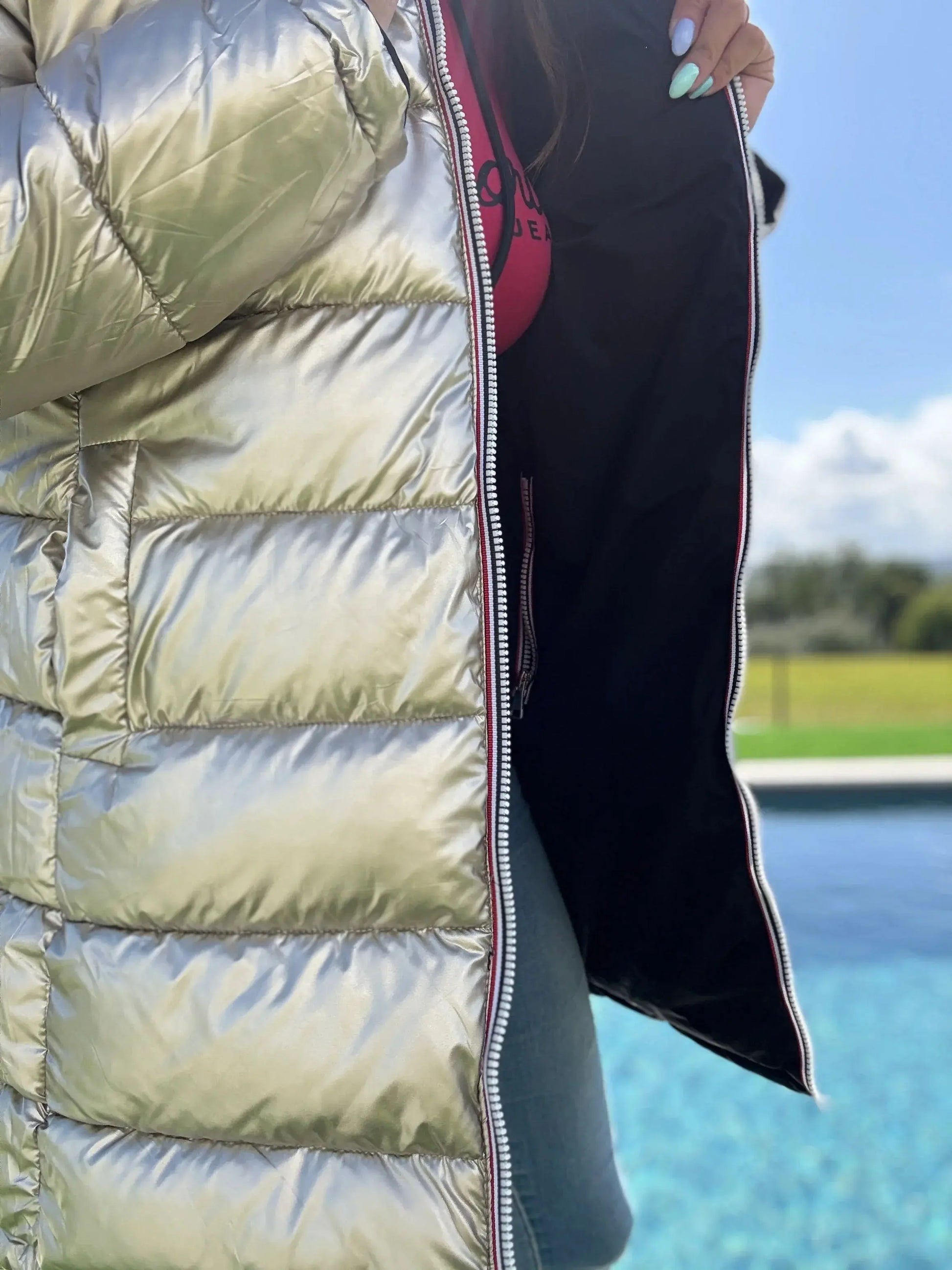 Manteau long réversible noir et doré Melya Melody, imperméable et matelassé, porté en plein air.