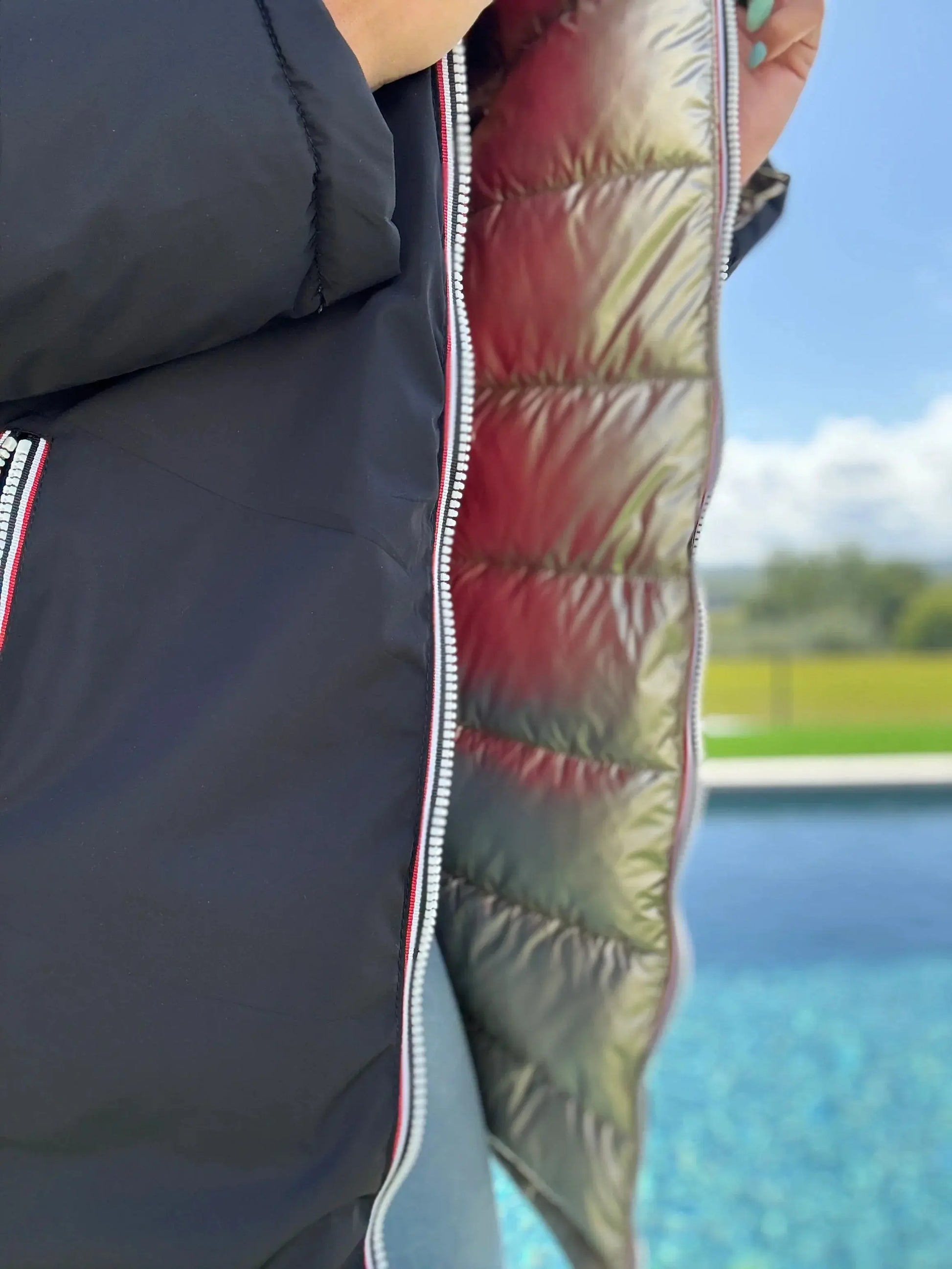 Manteau long réversible Melya Melody, imperméable et matelassé noir/doré, avec doublure visible en image.