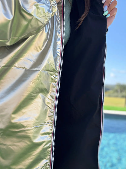 Manteau léger long réversible imperméable Melya Melody en noir avec détails dorés, porté en pleine longueur.