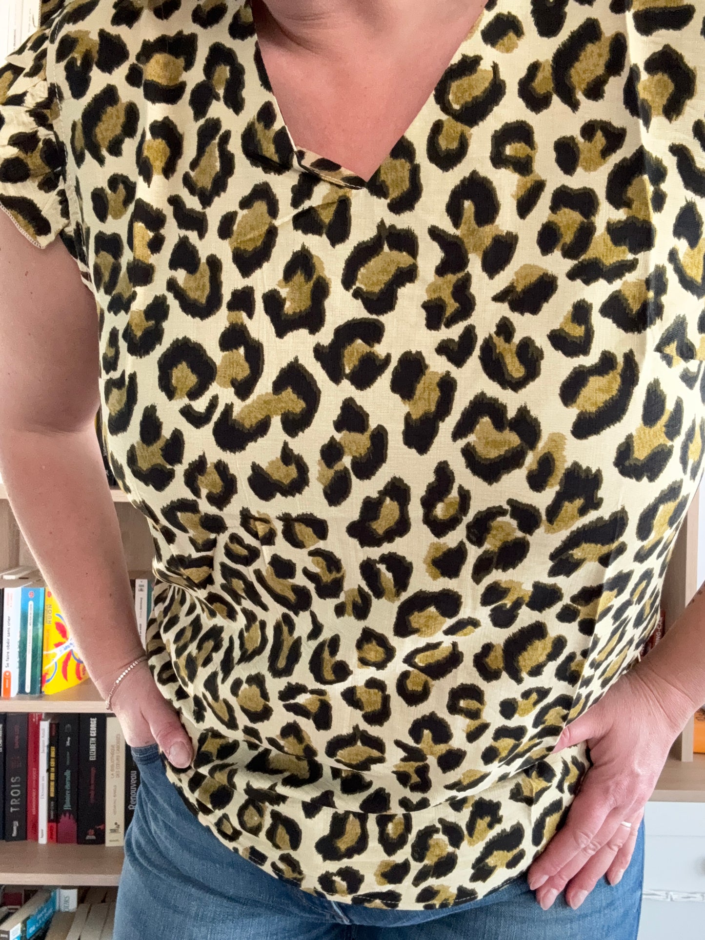 Détail du motif léopard vert kaki sur t-shirt femme col V à volants