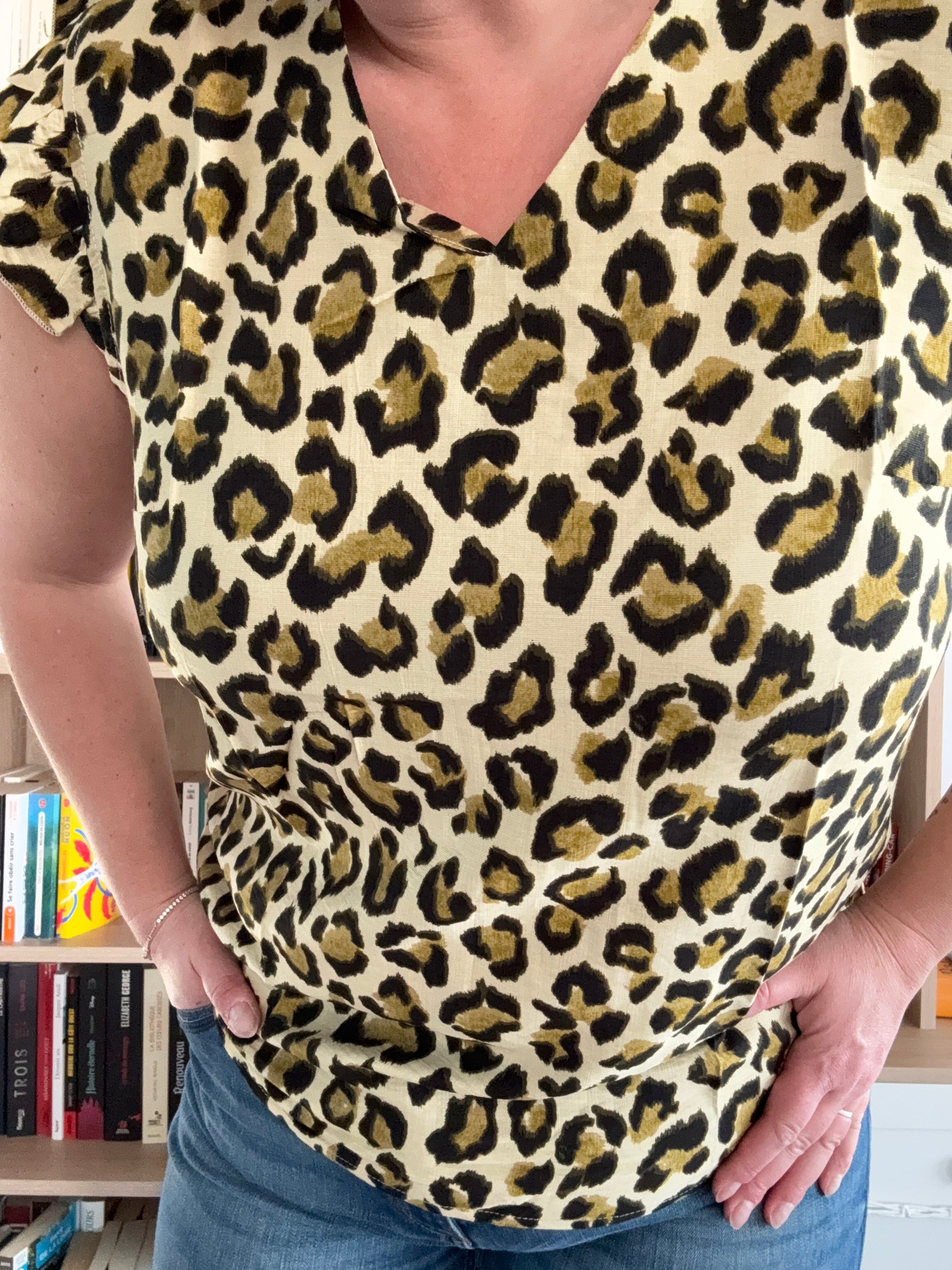 Détail du motif léopard vert kaki sur t-shirt femme col V à volants