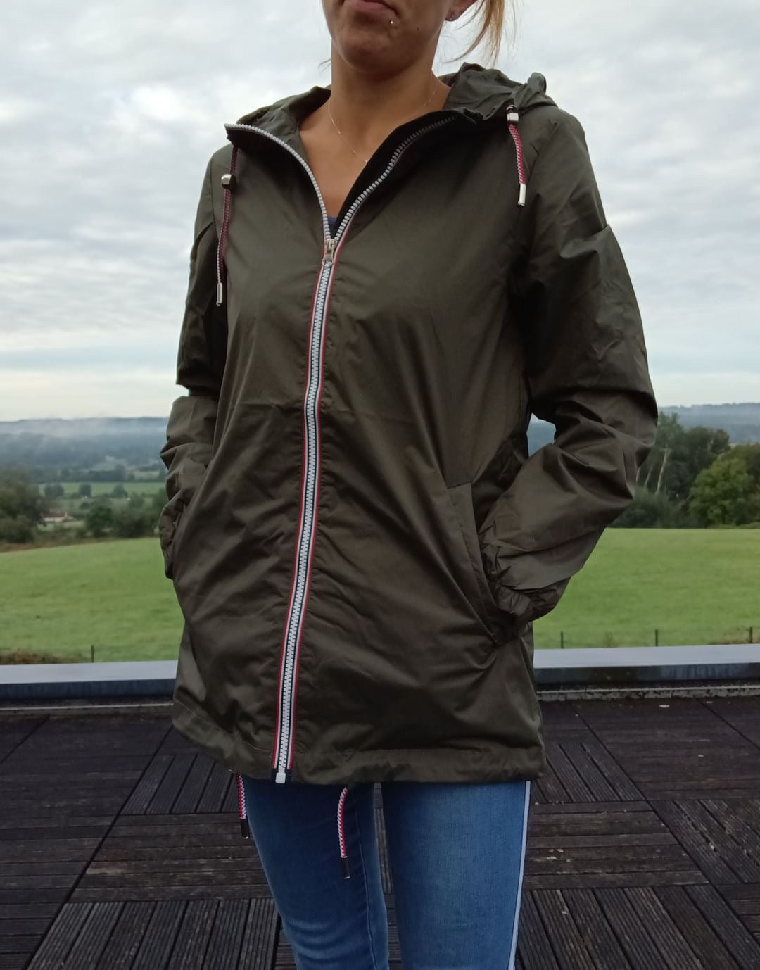 Femme portant un imperméable kaki Laura Jo à l'extérieur sur une terrasse en bois, Le Petit Placard